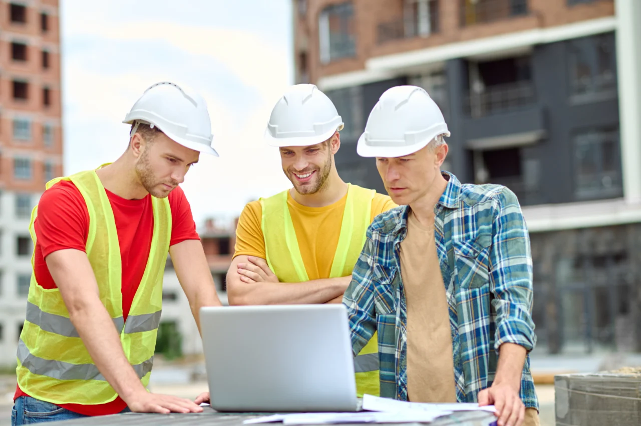 Trois ingénieurs du BTP discutant sur un chantier — Meilleure gestion des chantiers grâce à Odoo BTP